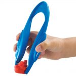 Child's hand picking up a toy ship with a pair of Learning Resources Easy Grip Childrens Tweezers