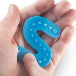 Child's finger tracing the arrows on an S from the Learning Resources Tactile Letters Set