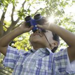 Child using the Learning Resources Rubberised Binoculars with Compass
