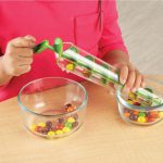 Child using the Learning Resources Archimedes Screw Science Toy to screw up sweets