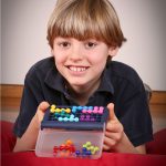 Boy playing Smartgames IQ Fit puzzle game