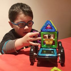 Child playing with vehicle made out of Magformers