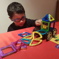 Child playing with vehicle made out of Magformers