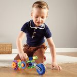 Child playing with a motorbike made from gears