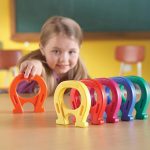 Child places a row of jumbo magnets from Learning resources
