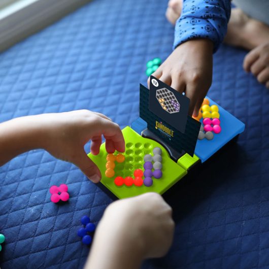 Little hands playing Kanoodle Head to Head