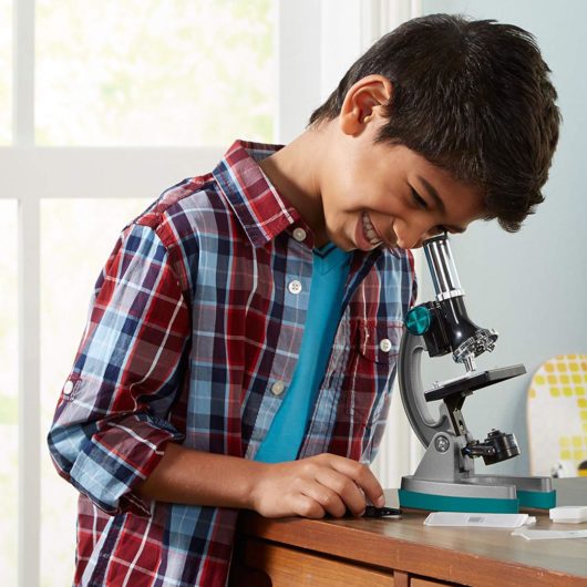 Child using the Geosafari MicroPro 48 Piece Microscope Set