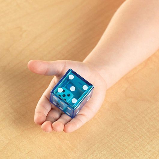 Young child's hand holds Learning Resources Jumbo Dice In Dice